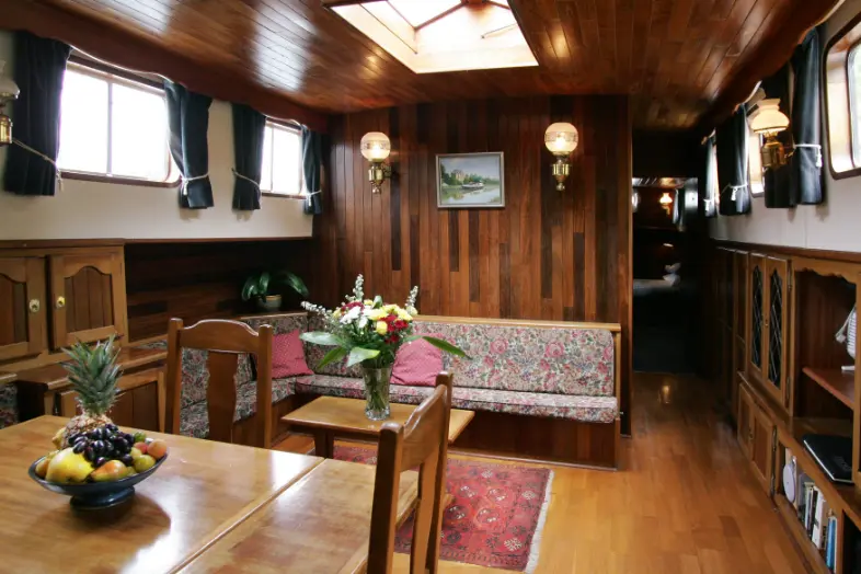 Wooden panelled interior saloon area of hotel barge.