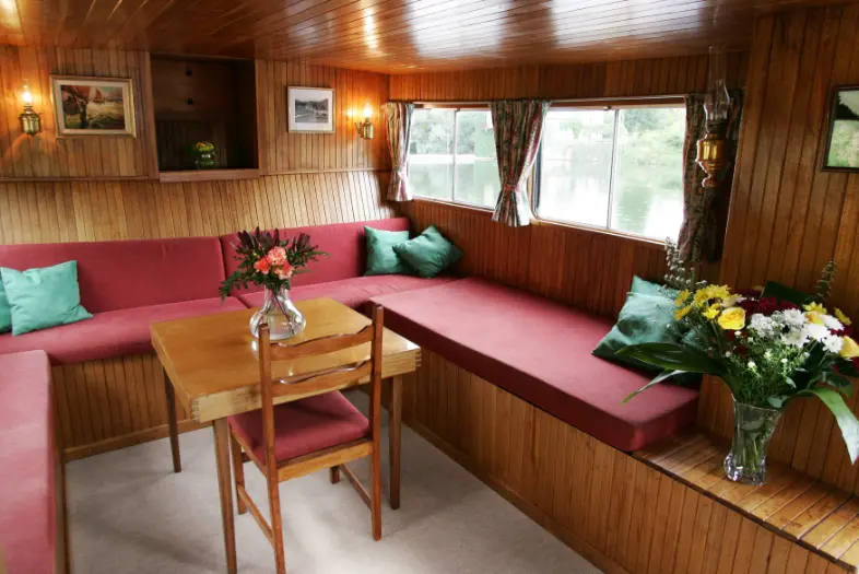 Upper saloon of hotel barge with views of the waterways.