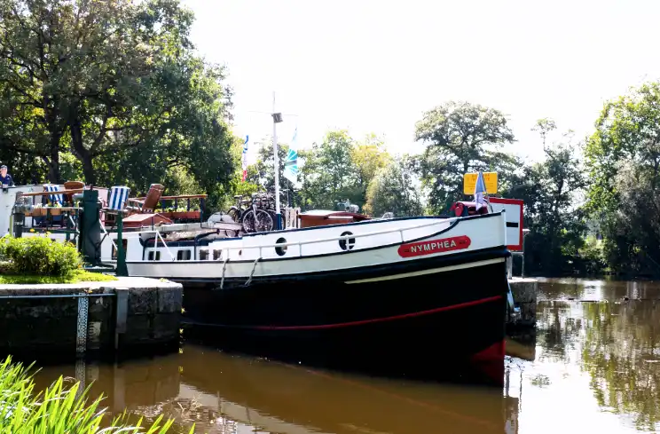 Hotel barge leaving a French lock in Brittany showing the bow.